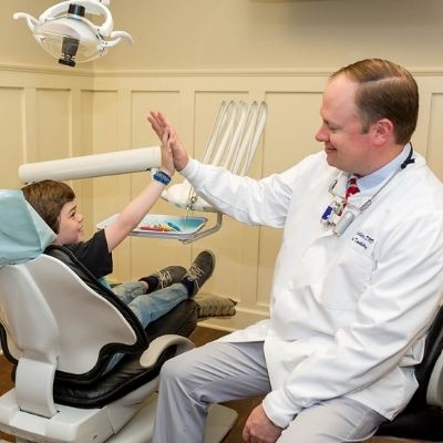Dr. Lance Collier giving a young male patient a high five